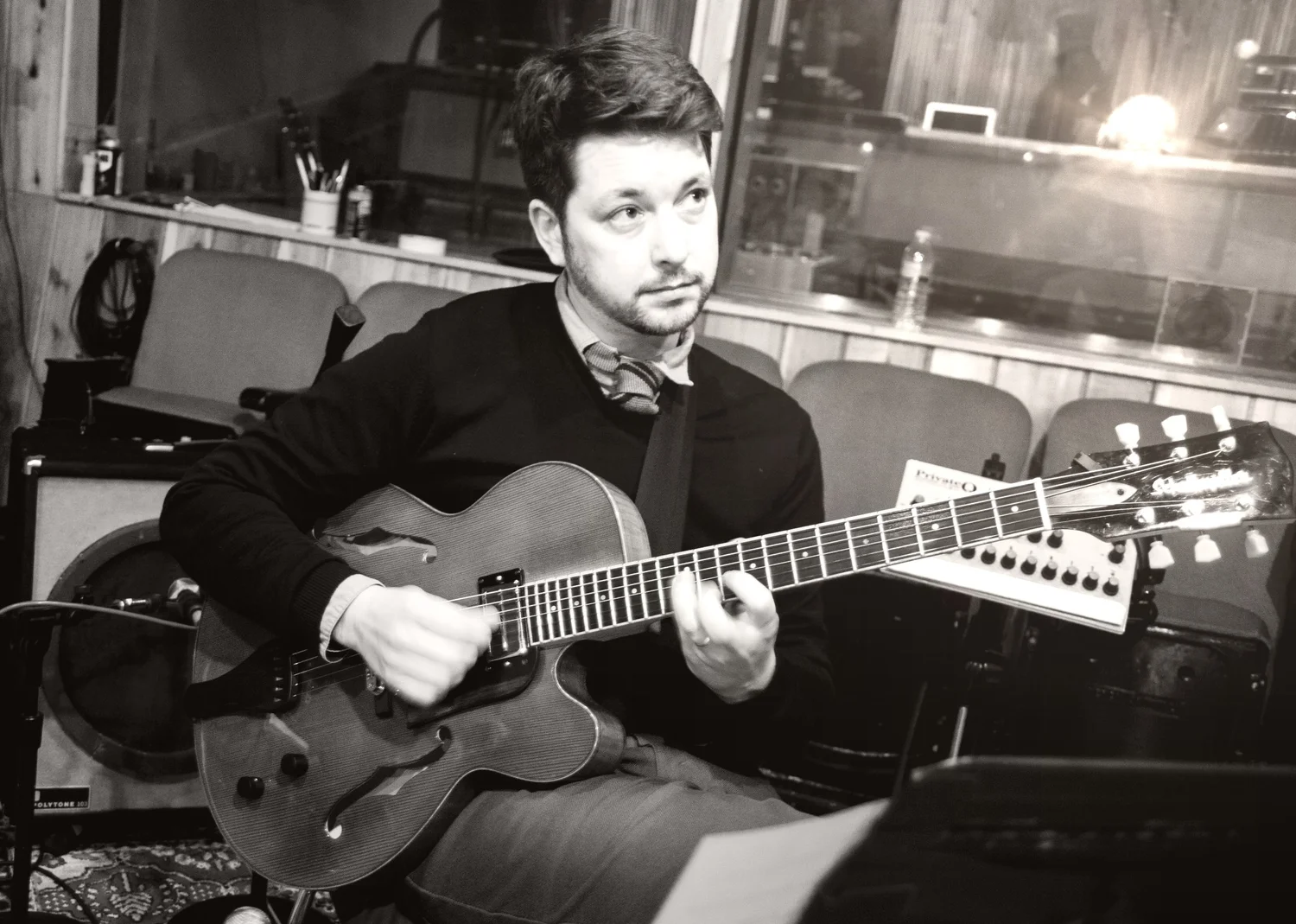 Lage Lund seated with his guitar in the recording studio